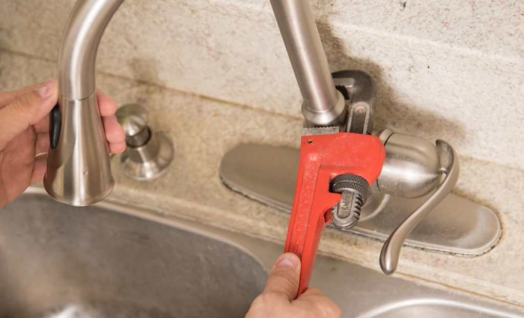 Plumber Using Wrench Tighten Water Faucet Kitchen